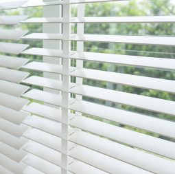 Close up view of window with horizontal blinds. White Roller Bli
