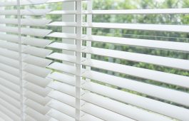 Close up view of window with horizontal blinds. White Roller Bli